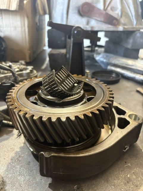 Stripped gearbox showing gear cluster and needle roller bearings during a clutch and transmission diagnosis
