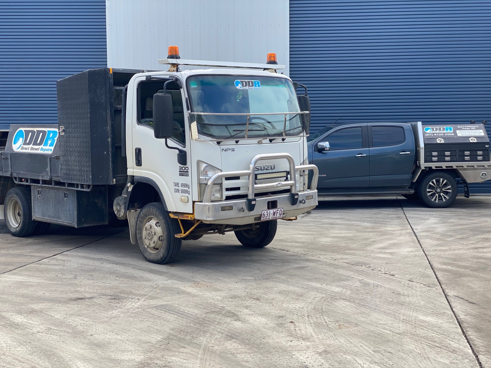 Direct Diesel Repairs Isuzu service truck and branded ute parked outside the Urangan workshop