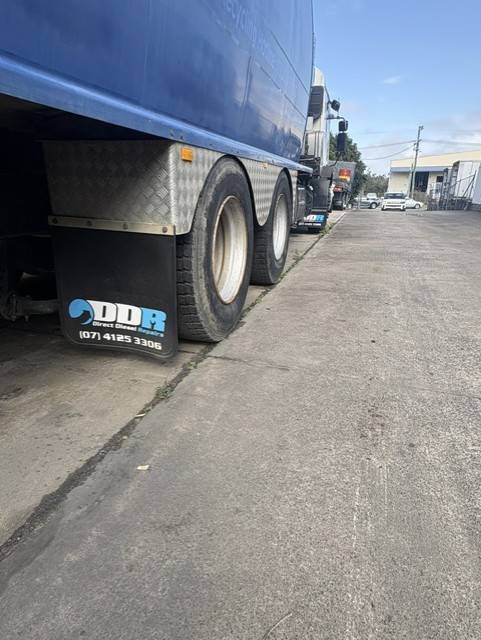 Heavy truck with a Direct Diesel Repairs mudflap parked outside the Hervey Bay approved inspection station