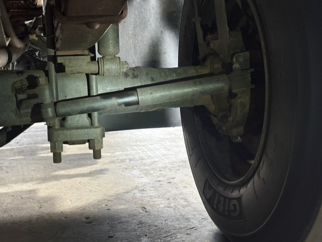 Underbody view of a heavy vehicle shock absorber and leaf spring assembly during a suspension check